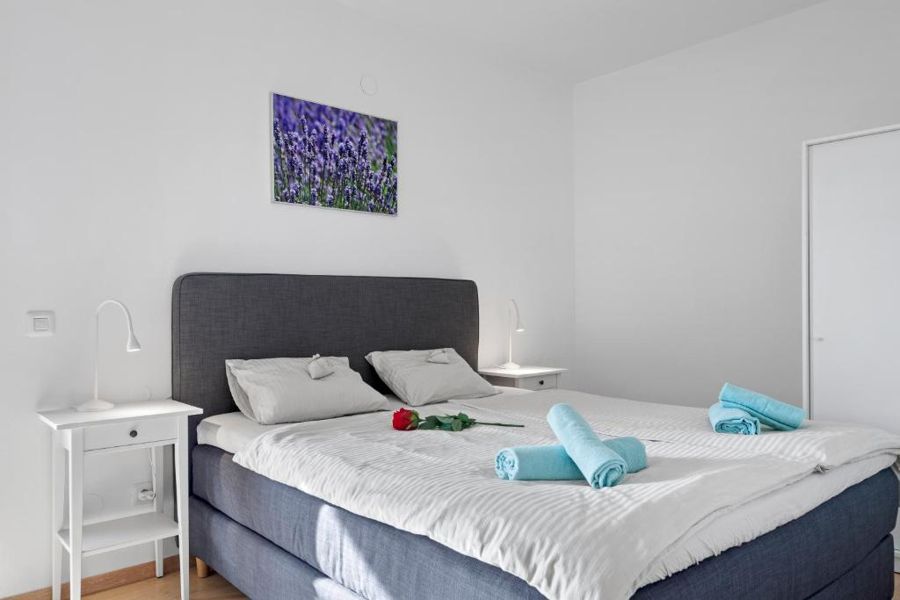Bedroom with fresh towels and a rose on the bed