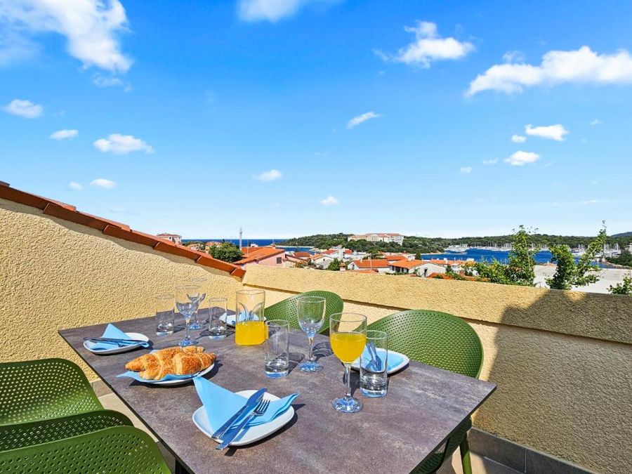 Breakfast table on the roof terrace, with a view over the bay